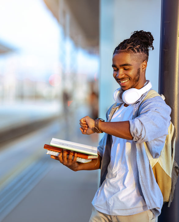 Ein Student am Bahnhof pr&uuml;ft die Uhr und steht f&uuml;r flexible Arbeitsmodelle, die sich gut mit Studium und Alltag vereinbaren lassen.