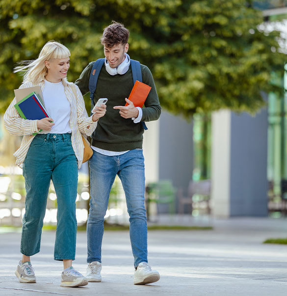 Zwei Studierende auf dem Campus symbolisieren die Verbindung von Studium, Berufseinstieg und praktischer Erfahrung.